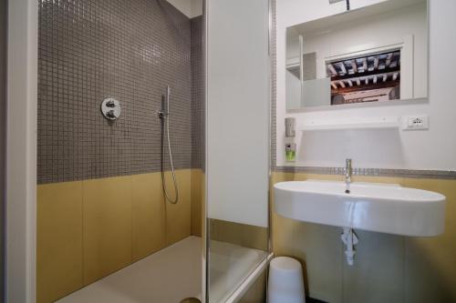 a bathroom with a sink and a shower at Le stanze del Piccadilly in Genova