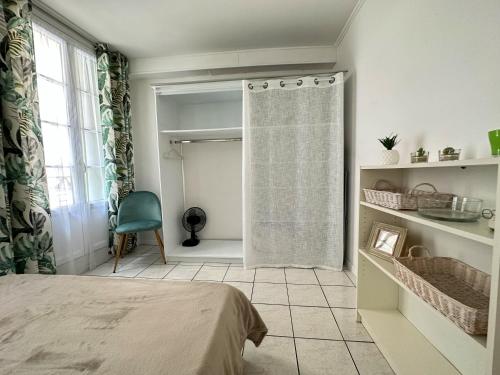 a bedroom with a bed and a shower curtain at Polichinelle *Central *Charmant *Calme in Pézenas