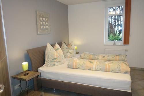 1 dormitorio con cama con almohadas y ventana en Ferienwohnung der weite Blick mit Wellness, en Winterberg