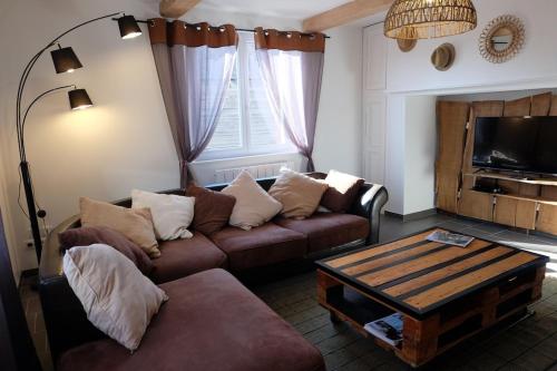 un salon avec un canapé et une table basse dans l'établissement Le GITE DU VILLAGE, à Franleu