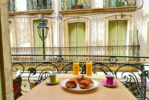 - une table avec deux assiettes de croissants dans l'établissement Polichinelle Hyper Centre - Wifi - Balcon & Parking Proche, à Pézenas