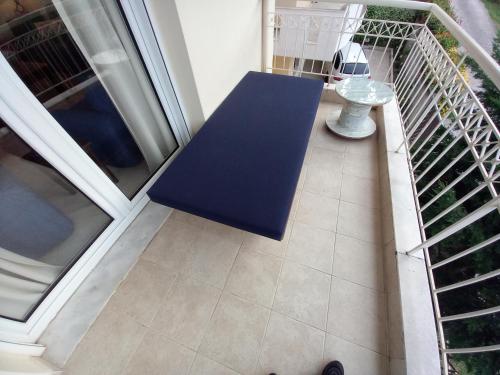 a blue bench on a balcony with a table at Χαλκιδική Κρυοπηγή in Kriopigi