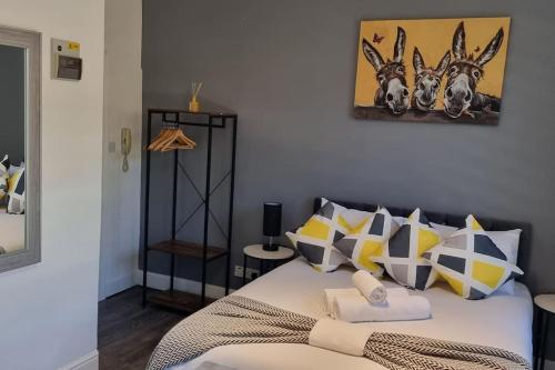 a bedroom with a bed with yellow and gray pillows at Modern Studio Oasis l 1Bed 1Bath l Central London in London