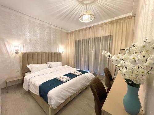een slaapkamer met een bed en een tafel met een vaas met bloemen bij Blue Apartment vue sur l’océan : Taghazout bay in Taghazout