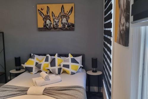- une chambre avec un lit doté d'oreillers jaunes et gris dans l'établissement Modern Studio Oasis l 1Bed 1Bath l Central London, à Londres