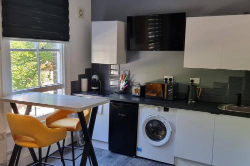 a kitchen with a table and a washing machine at Modern Studio Oasis l 1Bed 1Bath l Central London in London