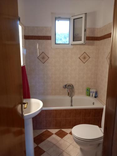 a bathroom with a tub and a toilet and a sink at Χαλκιδική Κρυοπηγή in Kriopigi