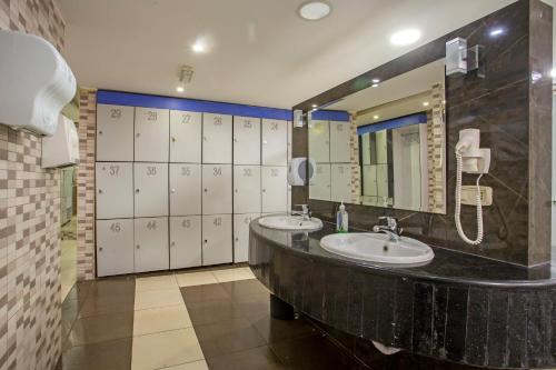 Sadeen Amman Hotel في عمّان: حمام به مغسلتين ومرآة كبيرة