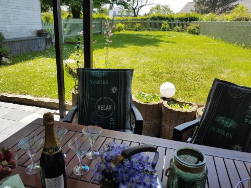 una mesa con una botella de vino y copas. en Apartment with garden in a wooded setting, en Auw