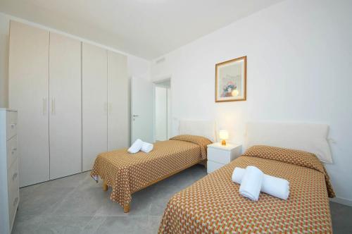two beds in a room with white cabinets at DolceVita Apartments N. 515 Redentore in Venice