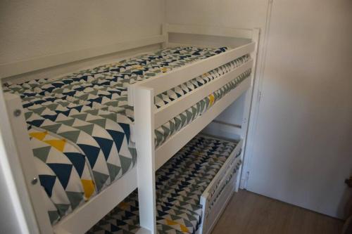 un placard avec un lit avec des motifs colorés dessus dans l'établissement Super studio pour 4 à proximité des plages, à Sausset-les-Pins