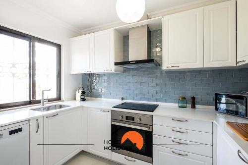 a kitchen with white cabinets and a stove top oven at #082 Fully Equiped with Pool, 450 mts Beach in Albufeira