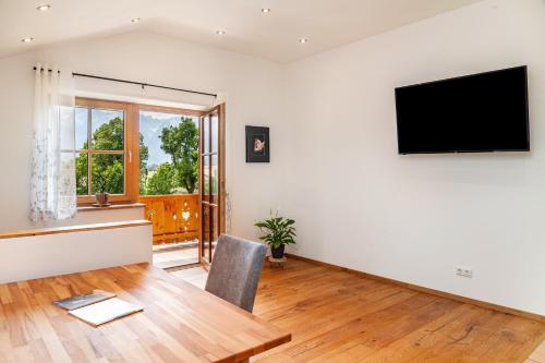 a living room with a flat screen tv on a wall at Ferienwohnung Rosalie in Farchant
