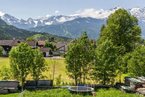 a group of trees in a field with mountains in the background at Ferienwohnung Rosalie in Farchant
