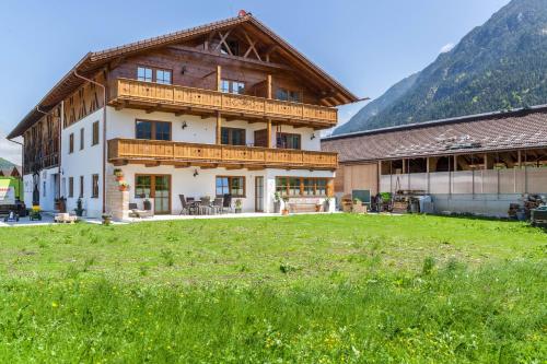 a large house with a green field in front of it at Ferienwohnung Rosalie in Farchant