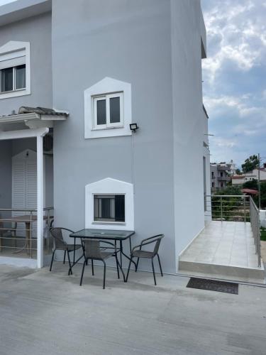 a patio with a table and chairs on a white building at Villa Kleo Ksamil in Ksamil