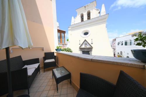 un balcón con mesa y sillas y un edificio en Don Raffaè - Luxury Apartment, en Isquia