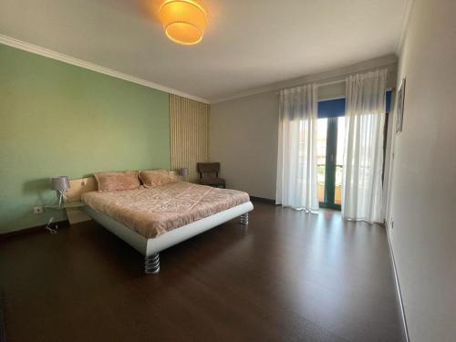 een slaapkamer met een bed en een groene muur bij Moradia praia de Esposende in Marinhas