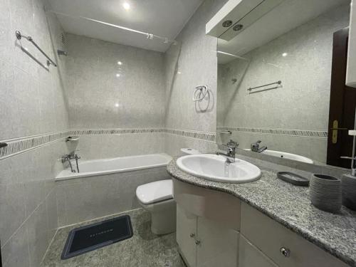 een badkamer met een wastafel, een bad en een toilet bij Moradia praia de Esposende in Marinhas