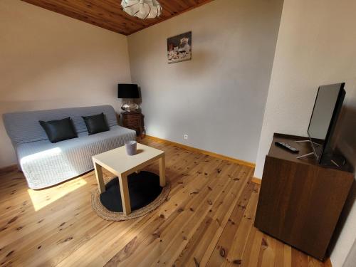 un salon avec un lit et une table dans l'établissement Maison proche viaduc de Garabit, à Loubaresse