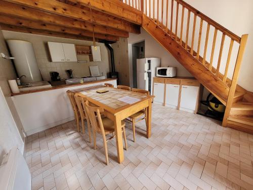 cocina y comedor con mesa de madera en Maison proche viaduc de Garabit en Loubaresse