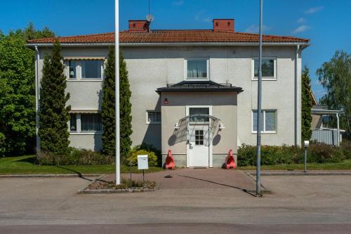 a large white house with a white door at Vandrarhemmet Stranden in Mora