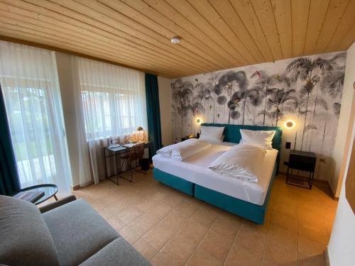 ein Schlafzimmer mit einem Bett und einem Sofa in der Unterkunft Strandhotel SüdSee Diessen am Ammersee in Dießen am Ammersee
