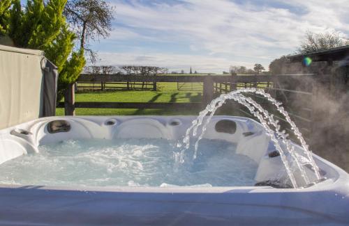 a pool with a water fountain in a yard at Greens Norton House in Towcester