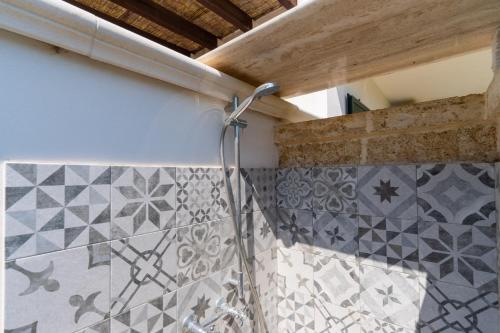 a shower in a bathroom with tiles on the wall at Villa Dalila by BarbarHouse in Torre Inserraglio
