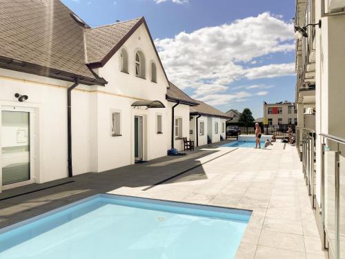 a swimming pool in the courtyard of a building at Wczasowa 8 Apartments in Sarbinowo