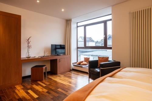 Dormitorio con cama, escritorio y TV en Prümer Gang Restaurant & Hotel, en Bad Neuenahr-Ahrweiler