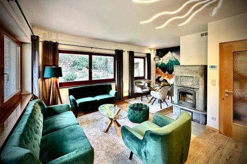 uma sala de estar com um sofá verde e uma lareira em DOLCEVILLA - Exklusiver Familienurlaub im Meraner Land em Vollan