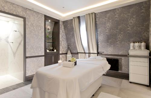 a spa room with two beds and a fireplace at Le Grand Hotel de Cabourg - MGallery Collection in Cabourg