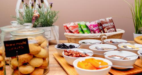 a table topped with bowls of fruit and snacks at Garni Hotel Mint in Belgrade