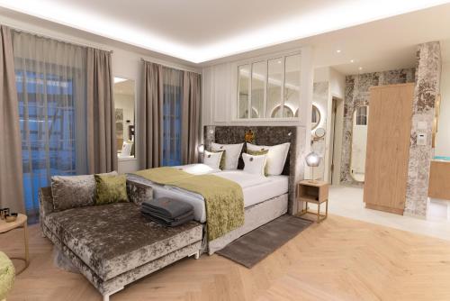 a large bedroom with a bed and a couch at SCHLOSSRESIDENZ - Boutique Apartments & Hotel Suiten in Schloß Ricklingen