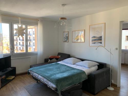 une chambre avec un lit et un canapé dans l'établissement Appartement Cosy proche du centre, à Annecy
