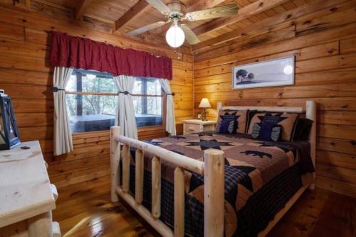 1 dormitorio con 1 cama en una cabaña de madera en Mountain Time Cabin, Hot tub, Fire Pit, Fireplace, en Blue Ridge