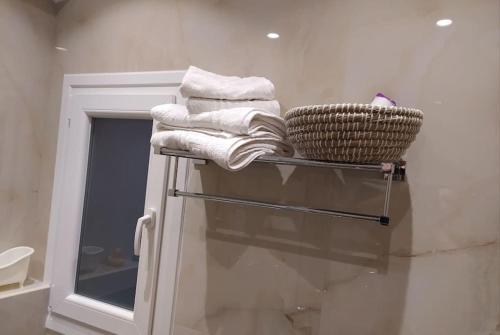 a bathroom with a rack with towels and a basket at Xenofon's cozy apartment in Corfu