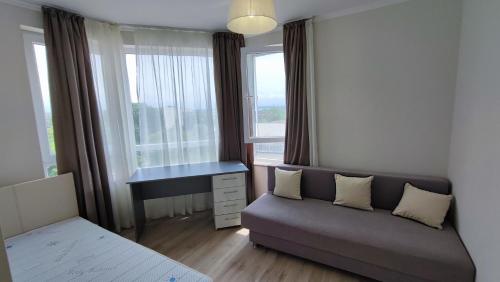 sala de estar con sofá, escritorio y ventana en Луксозен апартамент с две спални en Burgas