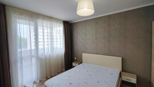 1 dormitorio con cama y ventana grande en Луксозен апартамент с две спални, en Burgas