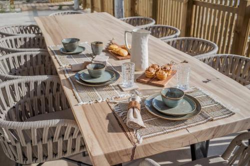 a wooden table with plates of food on it at Villa da Comporta - Apartamento T3 in Comporta
