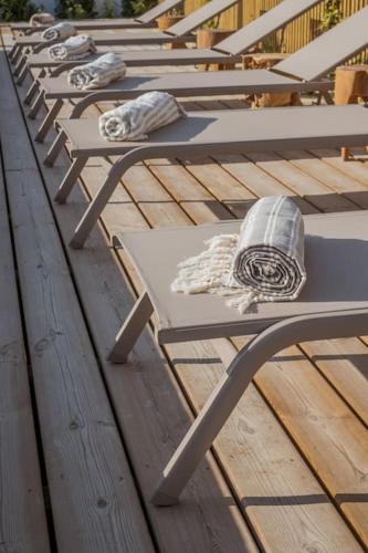 a row of benches sitting on top of a wooden deck at Villa da Comporta - Apartamento T3 in Comporta