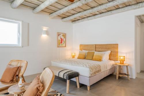 a white bedroom with a bed and two chairs at Villa da Comporta - Apartamento T3 in Comporta