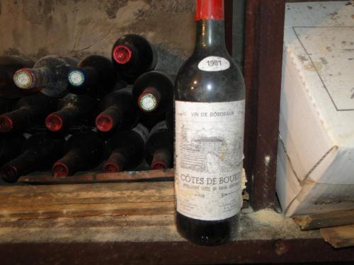uma garrafa de vinho sentada ao lado de um monte de garrafas de vinho em Chateau Monichot em Tauriac
