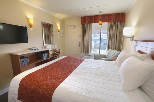 a hotel room with a large bed and a television at Fleur de Lis Beach Motel in Wildwood Crest