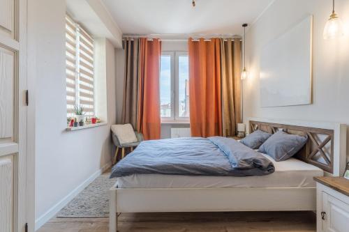 Schlafzimmer mit einem Bett und einem Fenster in der Unterkunft Apartament przy Stajennej in Danzig