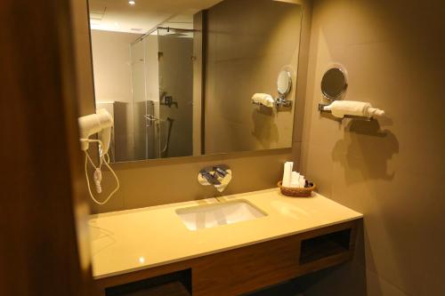 a bathroom with a sink and a large mirror at HOTEL CEASAR PALACE in Kottayam