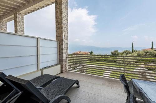a patio with chairs and a table on a balcony at Little Paradise Lake Garda in Toscolano Maderno