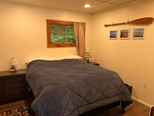 a bedroom with a bed and a window at Camp Lake Bear in South Colton