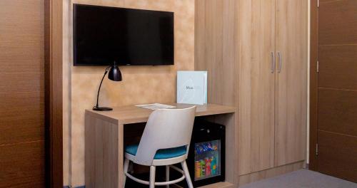 a room with a desk with a chair and a television at Garni Hotel Mint in Belgrade